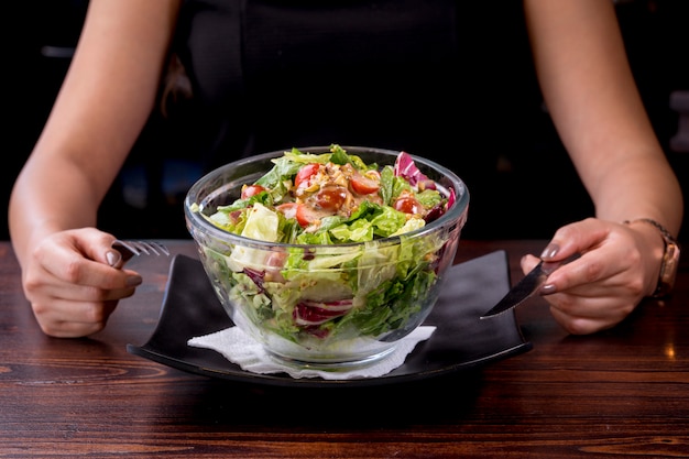 Jonge vrouw die heerlijke tonijnsalade, voedzaam en gezond voedsel eet - caloriearm dieet