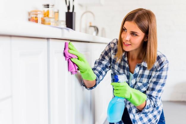 Foto jonge vrouw die het huis schoonmaakt