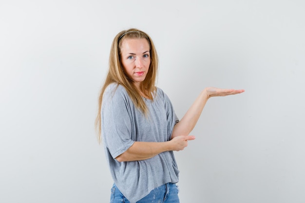 Jonge vrouw die het recht toont met haar hand op een witte achtergrond