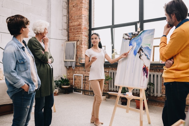 Foto jonge vrouw die het schilderen in art studio voorstellen