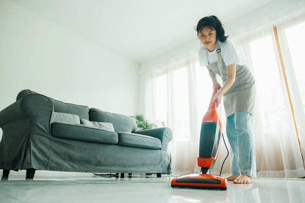 Jonge vrouw die huis schoonmaakt met stofzuiger