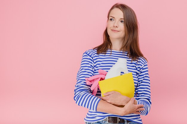 Jonge vrouw die huishoudelijke taken doet met wasmiddel met beschermende sponsrubberhandschoenen zorgt voor sanitaire slijtage casual blauw gestreepte trui