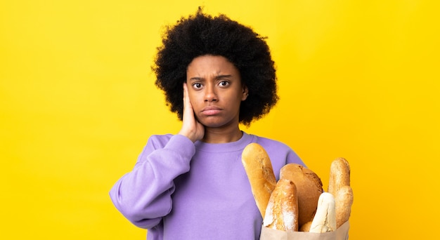 Jonge vrouw die iets brood koopt dat op gefrustreerd geel wordt geïsoleerd en oren behandelt