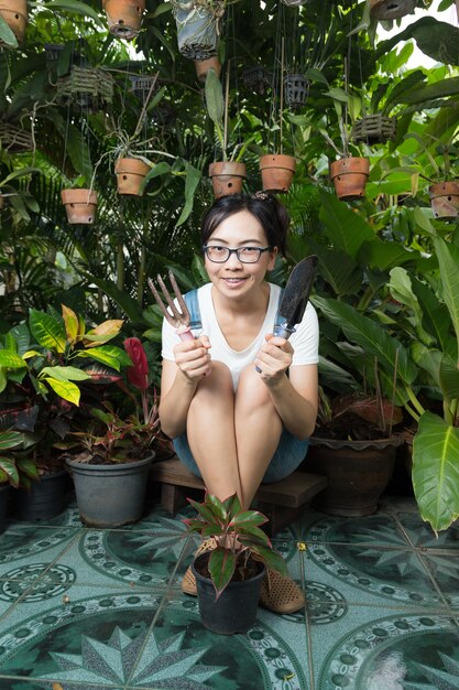 Jonge vrouw die in aard tuiniert.