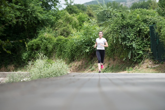 Jonge vrouw die in bebost bosgebied loopt en traint voor Trail Run Marathon Endurance Fitness gezonde levensstijl Concept