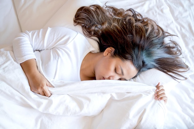 Foto jonge vrouw die in bed slaapt.