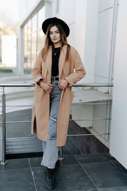 Jonge vrouw die in de stad loopt in bontjas, stedelijke straatstijl, wintermodetrend, accessoires