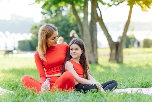 Jonge vrouw die in groen park met haar dochter rust