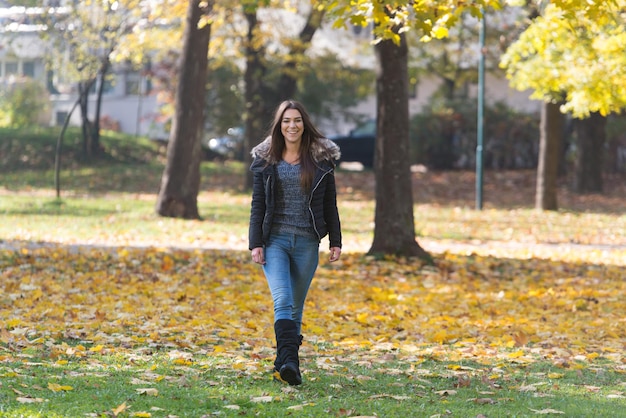 Jonge vrouw die in het herfstbos loopt