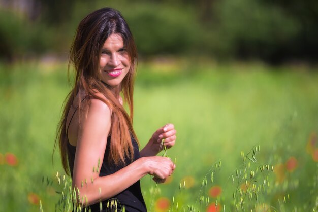 Jonge vrouw die in openlucht van Aard geniet. Gezonde lachend meisje in bloei lente weide