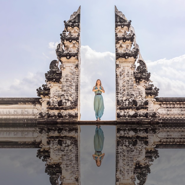 Jonge vrouw die in tempelpoorten staat bij de lempuyang luhur-tempel in bali, indonesië, vintage toon bali