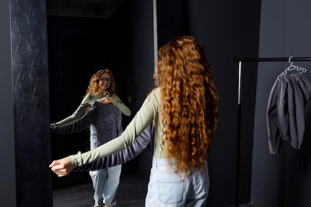 Jonge vrouw die kleren kiest bij de paskamer Winkelconcept