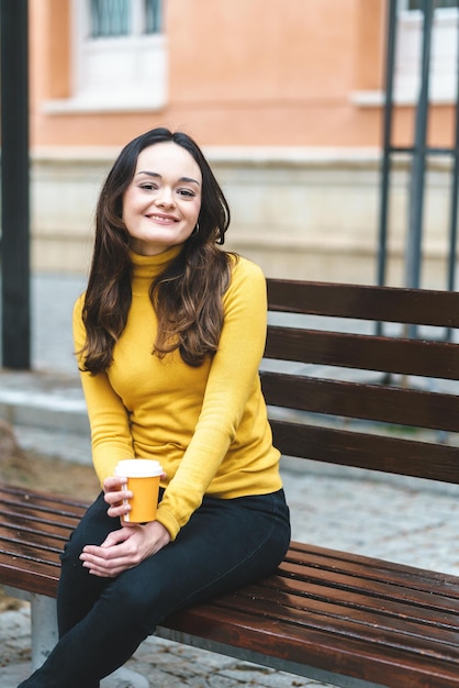 Foto jonge vrouw die koffie drinkt op straat