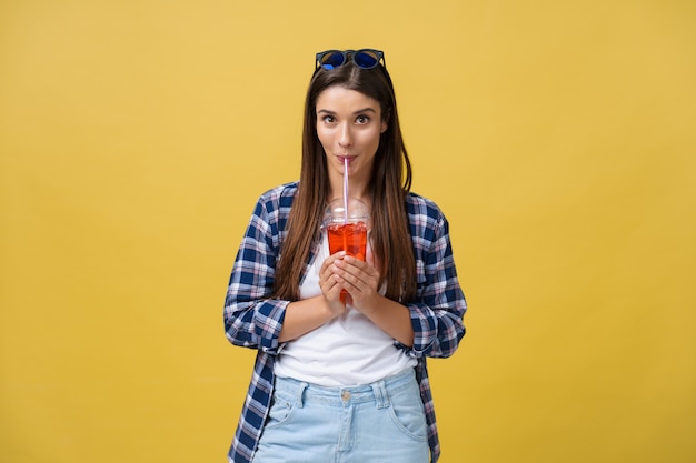 Jonge vrouw die koude drank vasthoudt en drinkt in vrijetijdskleding. mooi meisje glimlachend gelukkig lachen camera kijken.