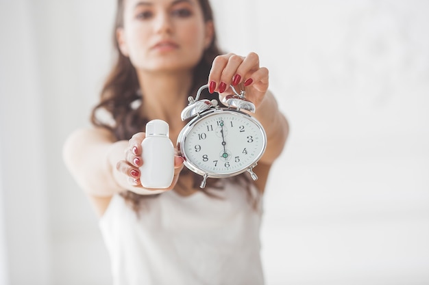 Foto jonge vrouw die laat zien dat het tijd is om pillen te slikken