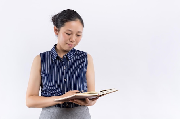 Jonge vrouw die lacht, gekleed in een pak met een boek