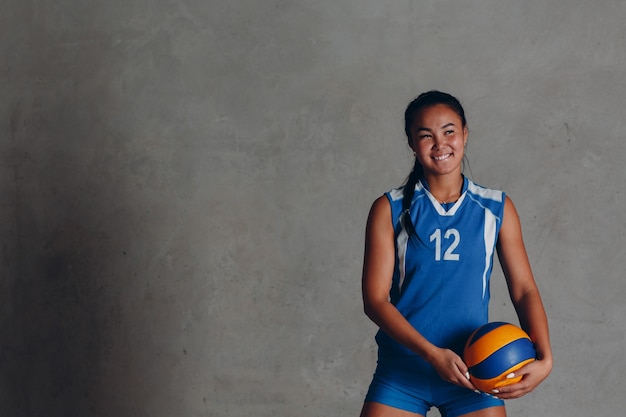 Jonge vrouw die lacht volleyballer met bal.