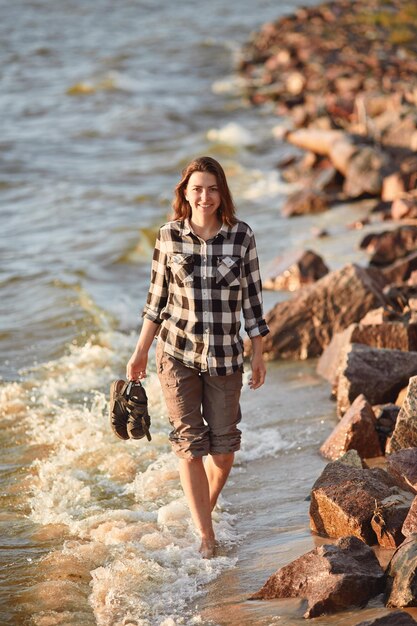 Jonge vrouw die langs strand loopt Landschap met mensen en kopieer ruimte