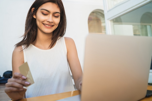 Jonge vrouw die laptop met behulp van om online te winkelen.