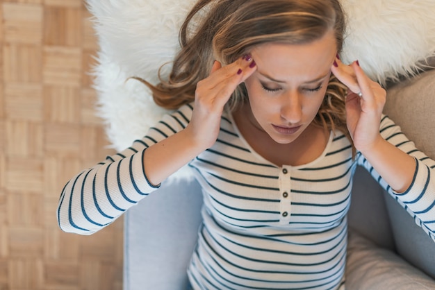 Foto jonge vrouw die lijdt aan hoofdpijn of migraine