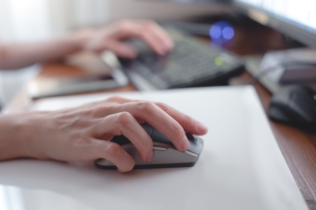 Jonge vrouw die met computer op kantoor aan huis werkt.