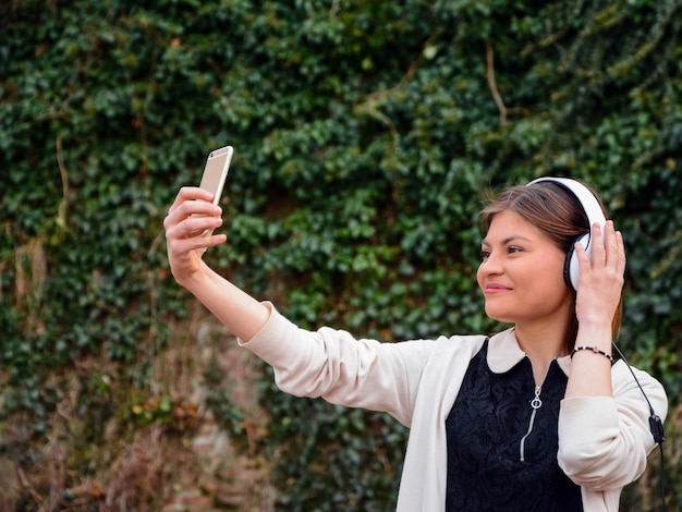 Jonge vrouw die met een mobiele telefoon fotografeert