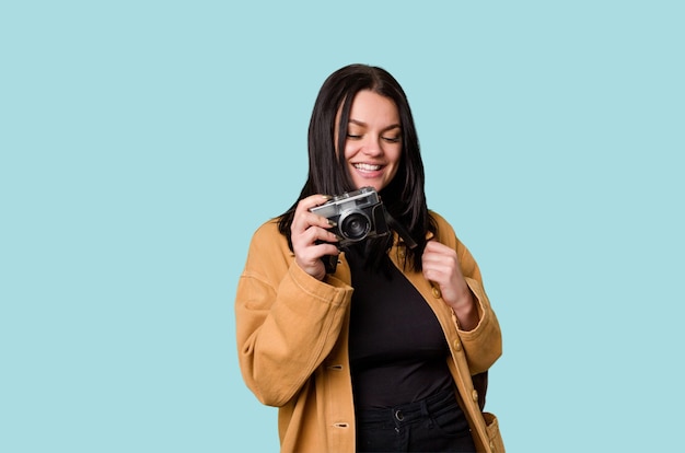 Jonge vrouw die met filmcamera glimlacht die door zoeker kijkt die door nieuwe hartstocht wordt opgewekt