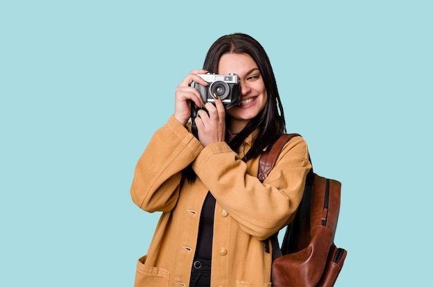 Jonge vrouw die met filmcamera glimlacht die door zoeker kijkt die door nieuwe hartstocht wordt opgewekt