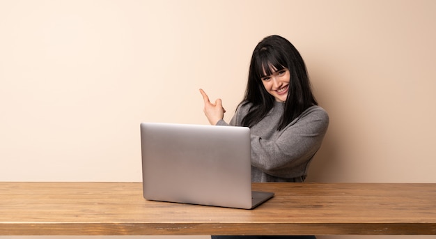 Jonge vrouw die met haar laptop werkt die terug richt