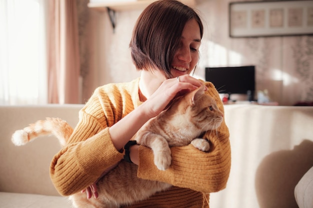 Jonge vrouw die met huisdier op de bank thuis rust