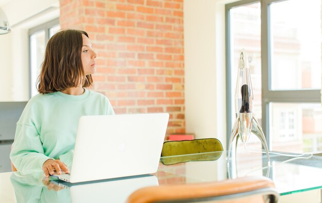 Jonge vrouw die met laptop werkt