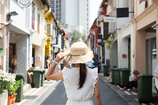 Jonge vrouw die met witte kleding en hoed reist
