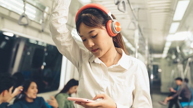 Jonge vrouw die mobiele telefoon op openbare trein met behulp van