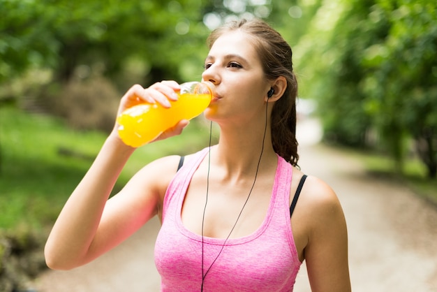 Jonge vrouw die na sport drinkt