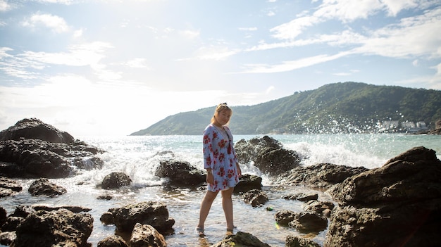 Jonge vrouw die naar de zee gaat en blij is om te ontspannen