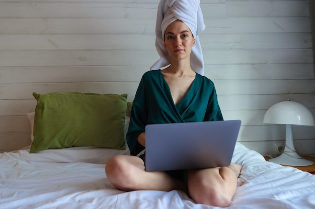 Jonge vrouw die op de computer werkt na een douche