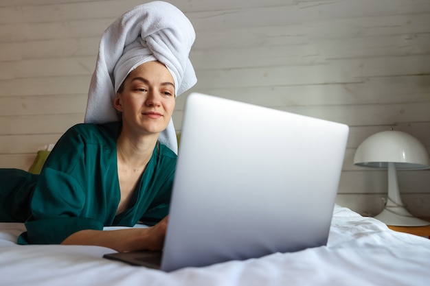 Jonge vrouw die op de computer werkt na een douche