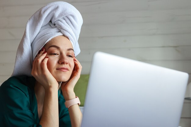 Jonge vrouw die op de computer werkt na een douche