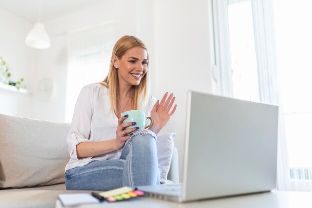 Jonge vrouw die op de laptop zwaait en via videogesprek met haar vrienden praat meisje student die via videoconferentie praat vrouwelijke leraar trainer bijles door webcam online training ecoaching concept