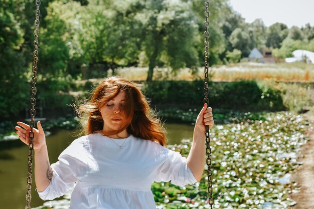 Foto jonge vrouw die op de speeltuin zwaait