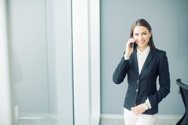 Jonge vrouw die op de telefoon spreekt