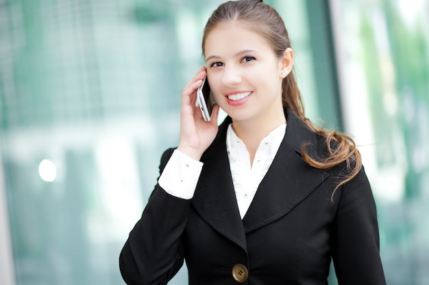 Jonge vrouw die op de telefoon spreekt