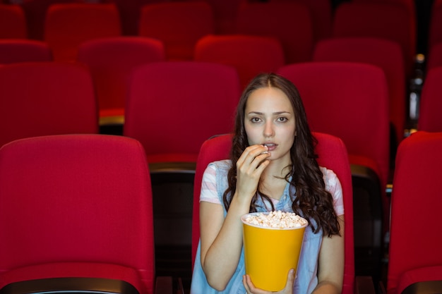 Jonge vrouw die op een film let