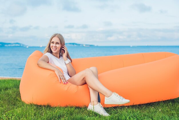 Jonge vrouw die op een luchtbank in het park rust