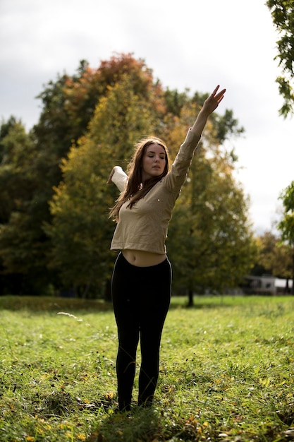 Foto jonge vrouw die op het veld danst