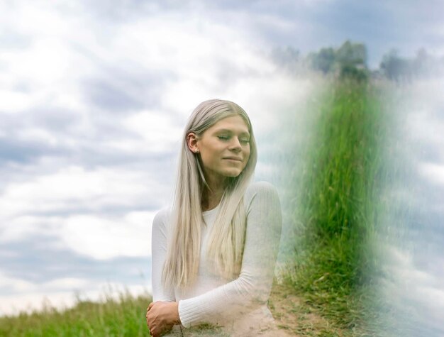 Foto jonge vrouw die op het veld tegen de lucht staat.