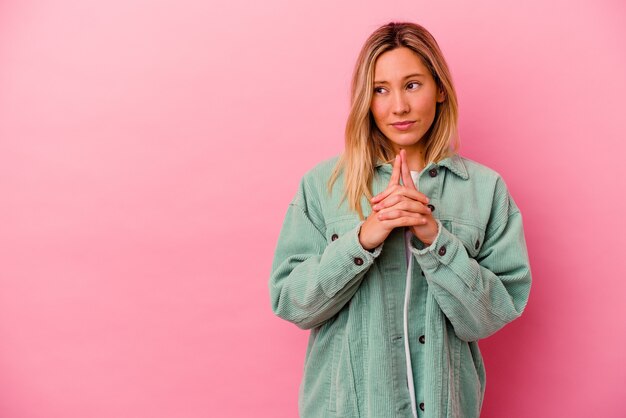 Foto jonge vrouw die op roze muur wordt geïsoleerd die plan in mening, het opzetten van een idee maakt