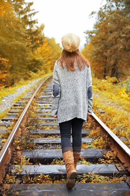 Jonge vrouw die op spoor van spoorlijnen loopt