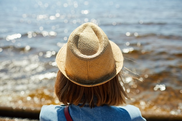 Jonge vrouw die op zee kijkt