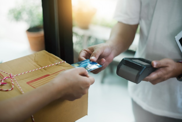 Jonge vrouw die pakket betaalt